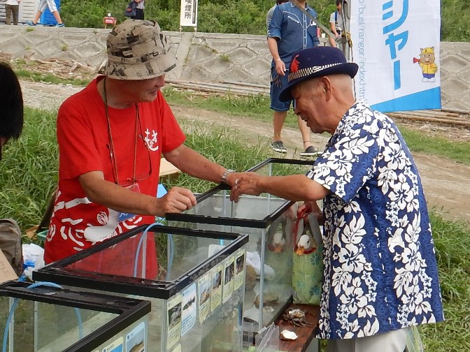 カニの説明をする田中レンジャー協力員